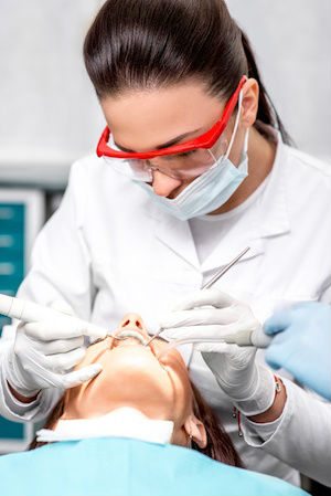 Dental hygienist working on a patient to perform a preventive procedure. 